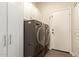 Laundry room with modern washer, dryer, and ample storage cabinets at 14099 W Riviera Dr, Surprise, AZ 85379