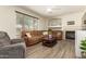 Comfortable living room features a cozy fireplace, large window, neutral walls, and durable wood-look floors at 14099 W Riviera Dr, Surprise, AZ 85379