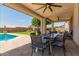 Covered patio with ceiling fans, outdoor dining, and view of the pool at 14099 W Riviera Dr, Surprise, AZ 85379