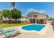 Inviting backyard pool, covered patio, grassy area, and lounge chairs create an ideal outdoor oasis at 14099 W Riviera Dr, Surprise, AZ 85379