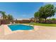 Beautiful backyard features a refreshing pool, grassy area, and lounge chairs perfect for relaxation at 14099 W Riviera Dr, Surprise, AZ 85379