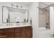 Bathroom features double sink vanity with a large mirror, gold fixtures, and a tiled shower at 14401 N 60Th Pl, Scottsdale, AZ 85254