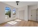 Bedroom featuring two large arched windows, light wood floors, and a closet with white doors at 14401 N 60Th Pl, Scottsdale, AZ 85254