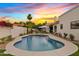 Beautiful backyard pool with a sunshade, desert landscaping, and clear blue skies at 14401 N 60Th Pl, Scottsdale, AZ 85254