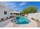 Sparkling backyard pool features desert landscaping, an umbrella, and lounge area at 14401 N 60Th Pl, Scottsdale, AZ 85254