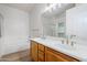 Bathroom featuring a double sink vanity, soaking tub, and glass enclosed shower at 15853 N 74Th Ave, Peoria, AZ 85382