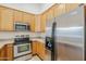 Gourmet kitchen featuring stainless steel appliances and light wood cabinets at 15853 N 74Th Ave, Peoria, AZ 85382