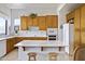 Well-lit kitchen featuring custom wood cabinets, white appliances, and an island with seating at 16364 E Ridgeline Dr, Fountain Hills, AZ 85268