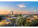Rooftop view showcasing an urban landscape with city buildings and palm trees during a colorful sunset at 17 W Vernon Ave # 508, Phoenix, AZ 85003