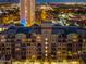 Night aerial view of a well-lit condo building with balconies and city views in the background at 17 W Vernon Ave # 508, Phoenix, AZ 85003