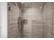 Beautiful shower featuring tiled walls, rainfall shower head, handheld wand, and inset shelving at 17 W Vernon Ave # 508, Phoenix, AZ 85003