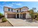 Beautiful home featuring two garages, desert landscaping, and a quaint front porch at 17153 W Gambit Trl, Surprise, AZ 85387