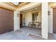 Welcoming front porch with seating area, decorative lanterns, and view of the front yard at 17153 W Gambit Trl, Surprise, AZ 85387