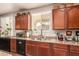 Kitchen area showcasing updated cabinets, granite counters, stainless sink, and window view at 17153 W Gambit Trl, Surprise, AZ 85387