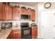Kitchen featuring granite countertops, stainless steel appliances, built-in microwave, and tile floors at 17153 W Gambit Trl, Surprise, AZ 85387