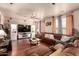 Spacious living room featuring a large sectional sofa, ceiling fan, and entertainment center at 17153 W Gambit Trl, Surprise, AZ 85387