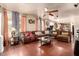 Expansive living room features a large sectional sofa, ceiling fan, and lots of natural light at 17153 W Gambit Trl, Surprise, AZ 85387
