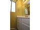 Bathroom with white vanity, laminate countertop, and a large mirror and bright yellow wall at 17606 N 17Th Pl # 1096, Phoenix, AZ 85022