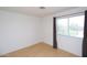 Spare bedroom with wood floors, white walls, a large window with curtains, and an outlet at 17606 N 17Th Pl # 1096, Phoenix, AZ 85022
