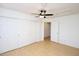 Bedroom boasts a ceiling fan, wood floors, and a spacious closet with white sliding doors at 17606 N 17Th Pl # 1096, Phoenix, AZ 85022