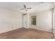 Neutral-toned bedroom with soft carpet, ceiling fan, and a window for natural light at 17828 W Calavar Rd, Surprise, AZ 85388