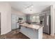 Well-lit kitchen featuring modern stainless appliances, center island, tile floors and light gray cabinets at 17828 W Calavar Rd, Surprise, AZ 85388