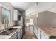 Well-lit kitchen featuring modern stainless appliances, center island, tile floors and light gray cabinets with view to backyard at 17828 W Calavar Rd, Surprise, AZ 85388