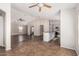 Spacious living room with tile flooring, fan, and light gray walls, offering seamless flow to the kitchen at 17828 W Calavar Rd, Surprise, AZ 85388