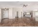 Spacious living room with tile flooring, fan, and light gray walls, offering seamless flow to the kitchen at 17828 W Calavar Rd, Surprise, AZ 85388