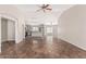 Spacious living room with tile flooring, fan, and light gray walls, offering seamless flow to the kitchen at 17828 W Calavar Rd, Surprise, AZ 85388