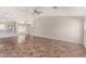Spacious living room with tile flooring, fan, and light gray walls, offering seamless flow to the kitchen at 17828 W Calavar Rd, Surprise, AZ 85388
