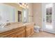 Bright bathroom featuring a granite countertop vanity, and a door leading to an outdoor space, bringing in natural light at 18029 W San Miguel Ave, Litchfield Park, AZ 85340