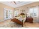 Cozy bedroom with a wooden bed frame, floral rug, and views to the backyard through white framed french doors at 18029 W San Miguel Ave, Litchfield Park, AZ 85340