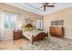 Serene main bedroom featuring a tray ceiling, shutters, and an area rug at 18029 W San Miguel Ave, Litchfield Park, AZ 85340