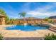 Stunning backyard pool with a waterfall feature and travertine tile surround at 18029 W San Miguel Ave, Litchfield Park, AZ 85340
