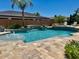 A relaxing pool with water features is surrounded by stone tiling at 18029 W San Miguel Ave, Litchfield Park, AZ 85340
