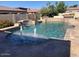 Large swimming pool with waterfall features and travertine tile surround, creating a luxurious backyard oasis at 18029 W San Miguel Ave, Litchfield Park, AZ 85340