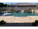 Beautiful swimming pool with built-in water features, complemented by travertine tile and lush greenery at 18029 W San Miguel Ave, Litchfield Park, AZ 85340