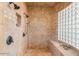 Expansive walk-in shower with a tile surround, multiple shower heads, a glass block window, and a built-in bench at 18029 W San Miguel Ave, Litchfield Park, AZ 85340