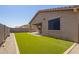 Inviting backyard with artificial turf, gravel accents, and a cozy covered patio area at 18637 W Williams Rd, Surprise, AZ 85387