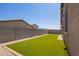 Low-maintenance backyard featuring artificial grass, gravel accents, and a block wall for privacy at 18637 W Williams Rd, Surprise, AZ 85387
