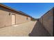 Long gravel-covered backyard, with an exterior door and block wall fence, offering minimal landscaping at 18637 W Williams Rd, Surprise, AZ 85387