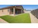 Spacious backyard featuring artificial grass, gravel accents, and a covered patio ideal for entertaining at 18637 W Williams Rd, Surprise, AZ 85387