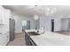 Open kitchen with white cabinets, stainless appliances, an island, and luxury vinyl flooring at 18637 W Williams Rd, Surprise, AZ 85387