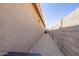 Side yard has a gravel pathway between the wall and the stucco house at 18637 W Williams Rd, Surprise, AZ 85387