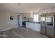Bright kitchen with white cabinets, stainless steel appliances, and modern gray wood-look flooring at 192 S Ralston Rd, Maricopa, AZ 85139