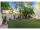 Lush green backyard with mature trees, brick accents, and a well-maintained lawn, perfect for outdoor enjoyment at 2110 W Navarro Ave, Mesa, AZ 85202