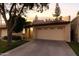 Charming home exterior at dusk showcases a well-maintained yard and a two-car garage at 2110 W Navarro Ave, Mesa, AZ 85202