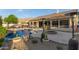 A backyard oasis featuring a private pool, fire pit, outdoor kitchen, and serene desert landscaping at 22204 N 55Th St, Phoenix, AZ 85054