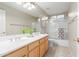 Bright bathroom with dual sinks, wood cabinets, and tiled floors at 22204 N 55Th St, Phoenix, AZ 85054